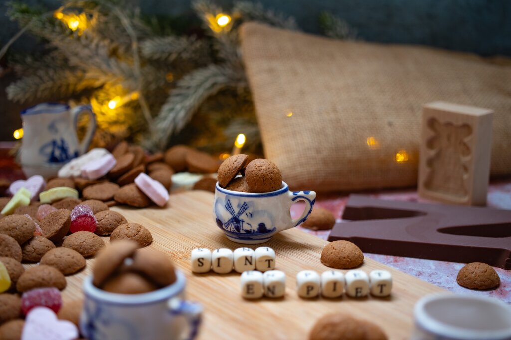 Pepernoten op een tafel, met andere snoepjes en de letters "Sint en Piet".